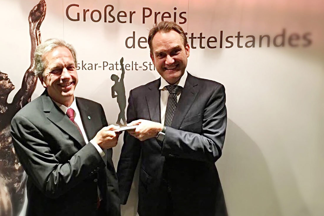 Dirk Hönscheid (links) und Oliver Grün (rechts) mit der Preisträgerstatue als Finalist des „Großer Preis des Mittelstandes“.